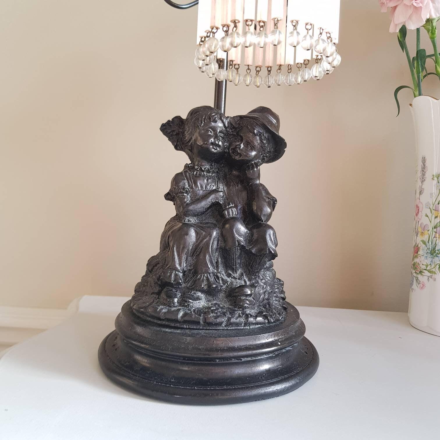 French Art Nouveau Table Lamp with Seated Children Statue and Pink Fringe Shade, 1930s Lighting for Bedroom or Side Table