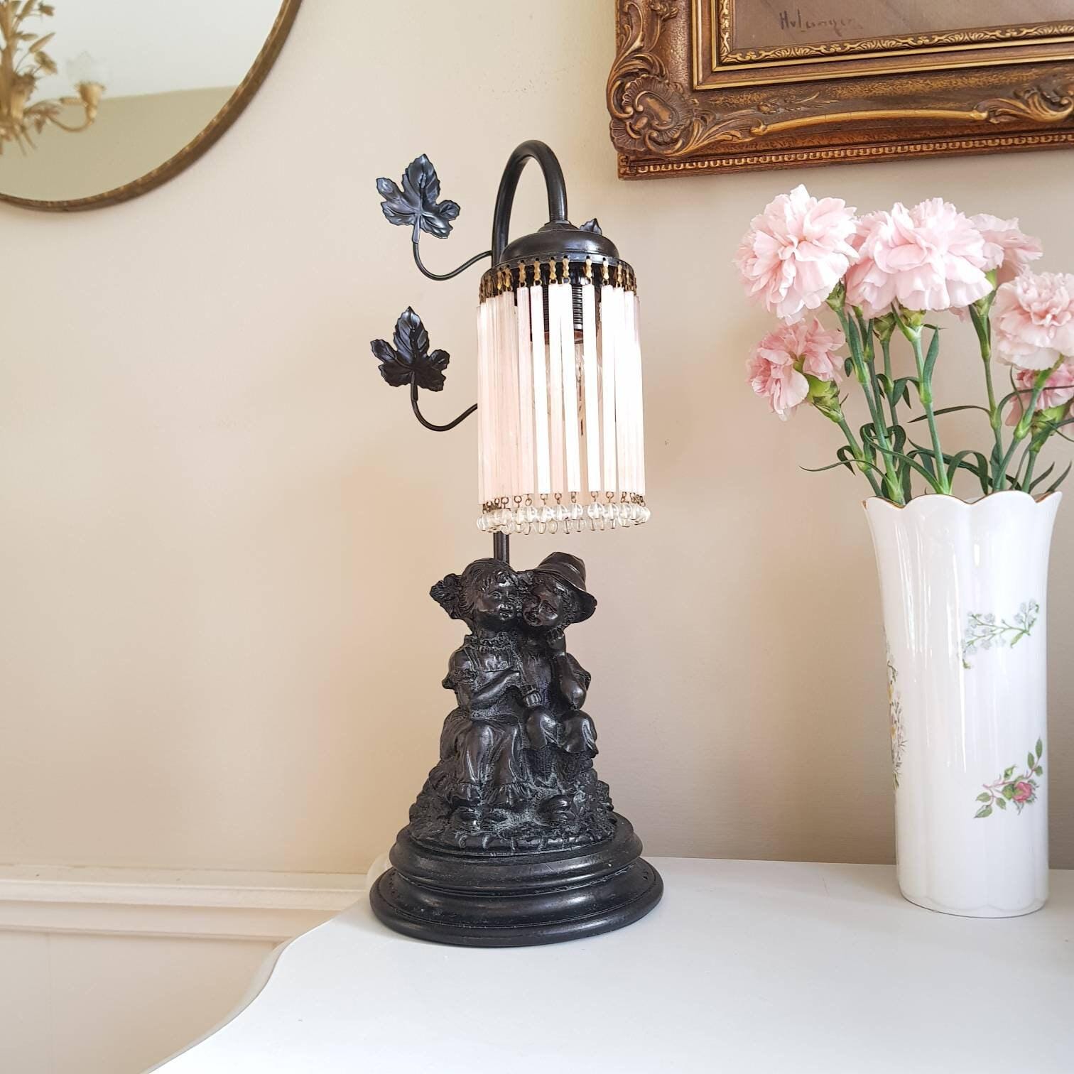 French Art Nouveau Table Lamp with Seated Children Statue and Pink Fringe Shade, 1930s Lighting for Bedroom or Side Table